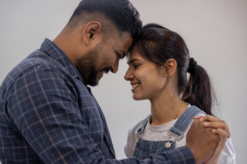 Obraz premium Happy Indian young couple adult caucasian man woman husband and wife dancing at home house