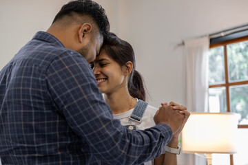 Happy Indian young couple adult caucasian man woman husband and wife dancing at home house