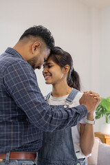 Fototapeta premium Happy Indian young couple adult caucasian man woman husband and wife dancing at home house