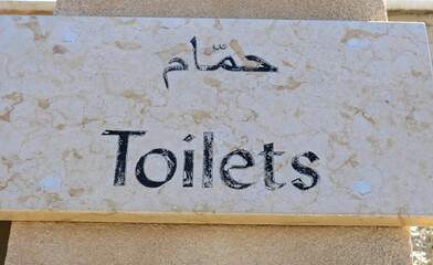 Bilingual text in Arabic and English indicating the Toilets