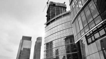 View of a skyscraper under construction. Modern architecture background. Building a high-rise building,  the concept of real estate construction. Black and white.