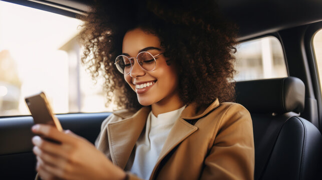 Smiling African American Woman With Mobile Phone In Car. A Young Black Woman Uses The Internet In The Car. The Concept Of Tenologies. Lifestyle.