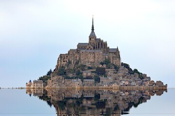 Reflected on the water at high tide of the ancient abbey of Mont Saint Michel in Normandy in France