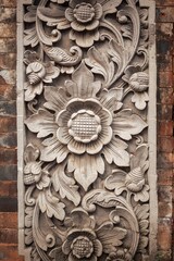 a large stone flower in a block in the middle of a brick wall