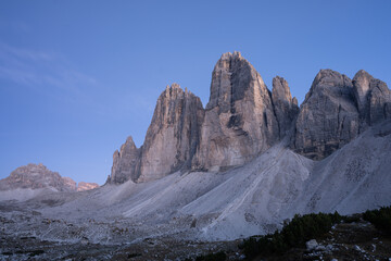 Last light of the day iluminating massive rock towers of Tre Cime, Dolomites, Italy