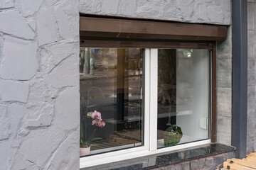 Small white PVC window. In the basement. With open shutters.