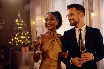 Happy multiracial couple enjoying in formal Christmas party at home.