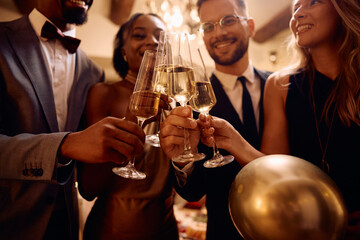 Close up of people toasting with champagne on New Year's Eve. - obrazy, fototapety, plakaty