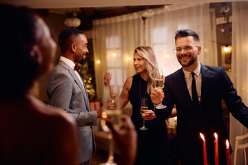 Happy friends have fun and drink champagne while celebrating New Year.