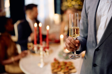 Close up of black man with glass of champagne during Christmas dinner party.