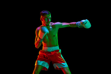 Talented shirtless boxer, mixed martial art fighter who preparing to fight against black mode background in mixed neon filter, light.