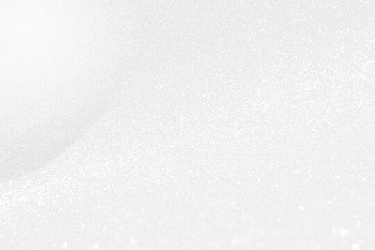 Abstract blurred white glitter background, selective focus, festive background idea