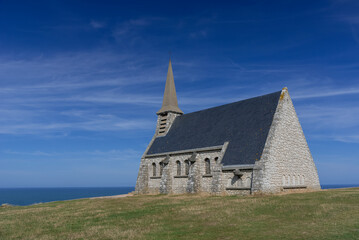 Fototapeta na wymiar La chapelle Notre-Dame-de-la-Garde située au sommet de la falaise d’Amont d'Étretat