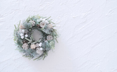 Christmas wreath on white stucco wall. 白い漆喰の背景上のクリスマスリース