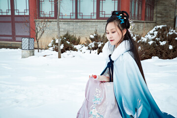 Obraz premium After a heavy snowfall, beautiful women in ancient costumes are seen in the scenic area