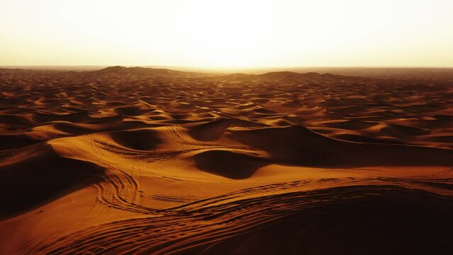 Aerial view of 4x4 off road land vehicle taking tourists on desert dune bashing safari in Dubai, UAE