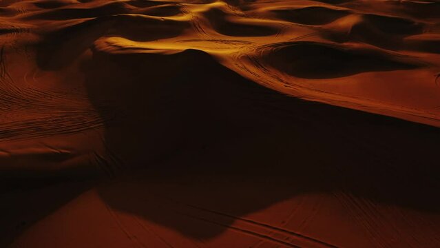 Aerial view of 4x4 off road land vehicle taking tourists on desert dune bashing safari in Dubai, UAE
