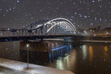 Pilsudski steel truss bridge over Vistula river in Krakow in the snowy night