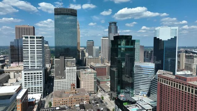 Downtown Minneapolis, Minnesota skyline. Aerial descending shot of modern cityscape against beautiful blue sky.