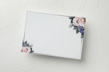 Blank invitation card on white table, top view