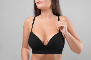 Woman with beautiful breast on light grey background, closeup
