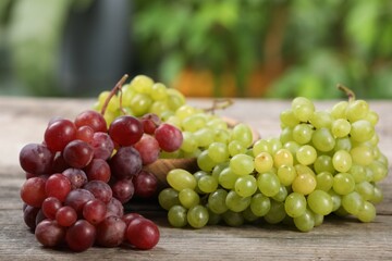 Different fresh ripe grapes on wooden table