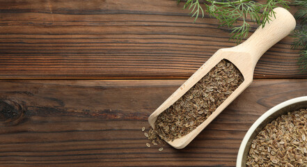 Dill seeds in scoop and bowl on wooden table, flat lay. Banner design with space for text