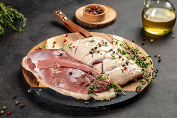 raw duck breast with ingredients for cooking on a dark background. top view. place for text