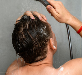 Mężczyzna myje włosy pod prysznicem - obrazy, fototapety, plakaty