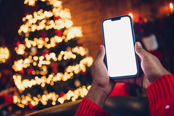 Closeup photo of human hands holding digital device new smartphone promote social media advertisement on xmas home illumination background