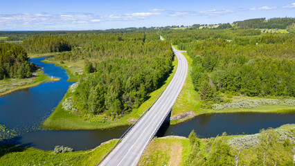 Road leading through beautiful swedish landscape with forests and lakes