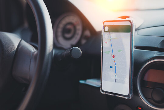 The phone's map appears on the dashboard and street in the background. White cell phone mounted in a mounting with GPS navigation and a map. duplicate the space. - Powered by Adobe