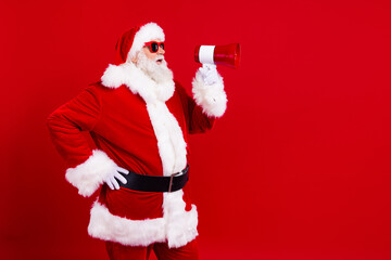Portrait of confident santa claus in stylish sunglass hold loudspeaker announcing sale to empty...
