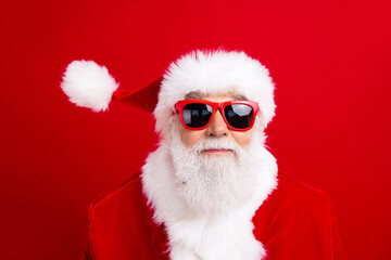 Photo of funky cool cheerful man santa claus wear sunglass celebrate xmas festival event new year magic isolated on red color background