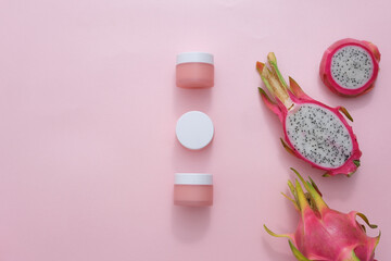 Obraz na płótnie Canvas Capture a top-down view of an unlabeled cosmetic jar surrounded by fresh dragon fruit and props on a pastel backdrop. Perfect for health and beauty-themed magazines, this image exudes elegance.