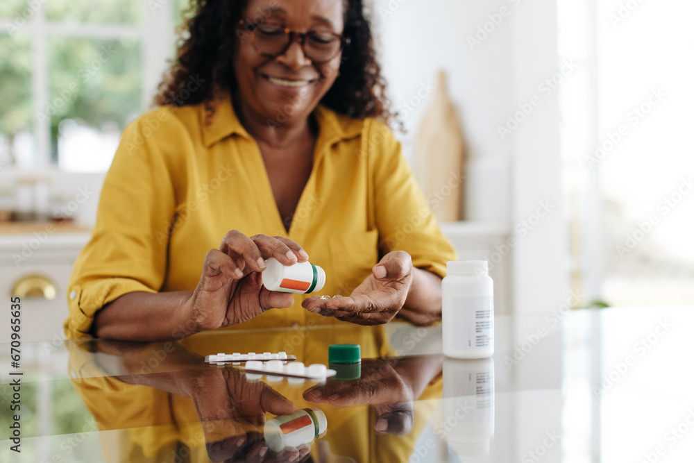 Wall mural medication adherence: mature woman taking tablets for a chronic health condition