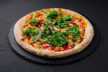 pizza with arugula on black board