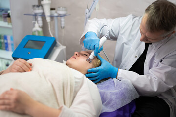 girl at a cosmetologist man during treatment procedures