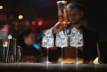 the bartender prepares a beautiful alcoholic cocktail at the bar counter