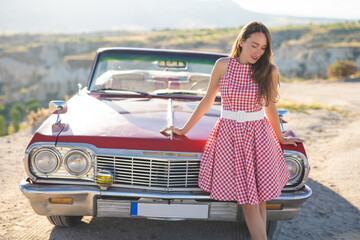 beautiful girl in a retro dress at sunrise happy posing on the background of the mountain landscape...