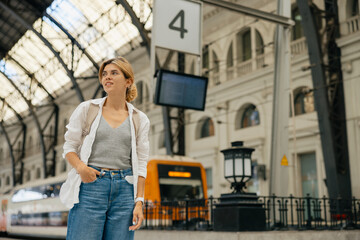 Adorable stylish girl on train station preparing for travel