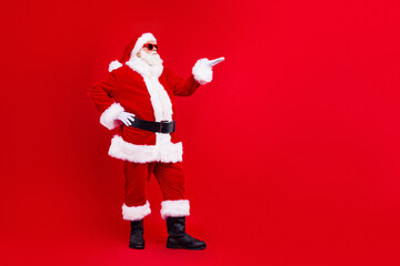Full size photo of satisfied grandfather wear santa costume demonstrate offer empty space arm on...