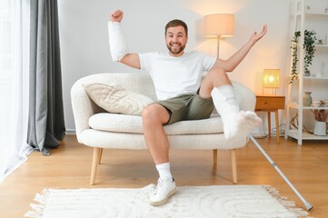 Happy man recovery from accident fracture broken bone injury with leg and arm. Social security and...