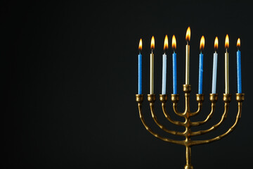 Hanukkiah with nine candles on black background, space for text