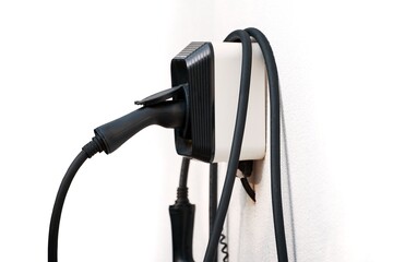 Isolated close-up of wall EV charger. Recharging sustainable transport at home. EV charger in a residential house. Clean power. Future transport technology.