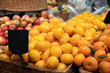 Tangerines and apples in wicker baskets in supermarket