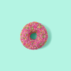 Pink donut on green blue background. Creative food concept.