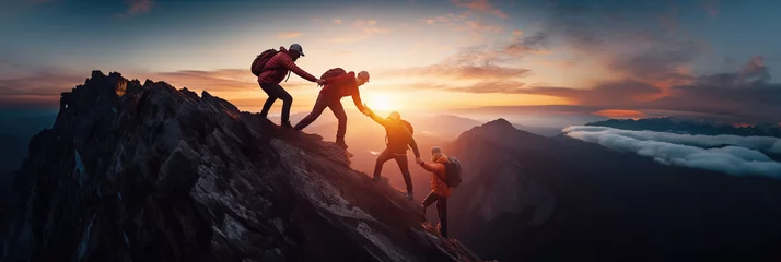 Foto op Canvas Panoramic view of team of people holding hands and helping each other reach the mountain top in spectacular mountain sunset landscape © IBEX.Media