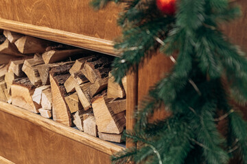 Cozy apartment, artificial electric bright fireplace with fake sparkling flame. Christmas Tree gifts presents garlands, decorated toys balls interior New Year
