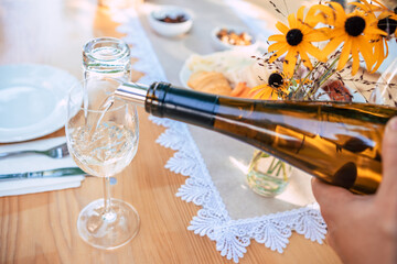 A person pouring wine to a glass